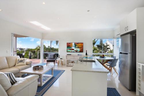a kitchen and living room with white furniture at Casa del Sol in Sunrise Beach
