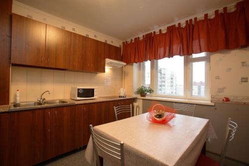 a kitchen with wooden cabinets and a table and a sink at Ostrovok Hotel in Saint Petersburg
