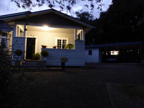 a white house with a light on the front of it at Bungalow on Bell Common in Tauranga