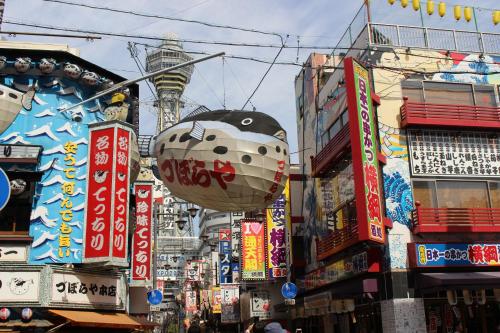 a busy city street with many signs and buildings at Hotel Sunplaza 2 in Osaka