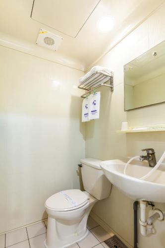 a bathroom with a toilet and a sink at Ruei Gung Business Hotel Kaohsiung in Kaohsiung