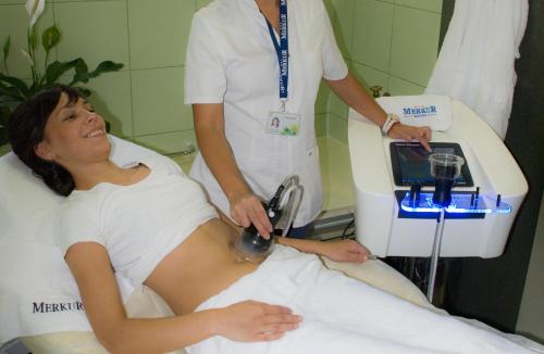 a woman laying in a hospital bed with a doctor at Medical and Spa Centre Merkur in Vrnjačka Banja