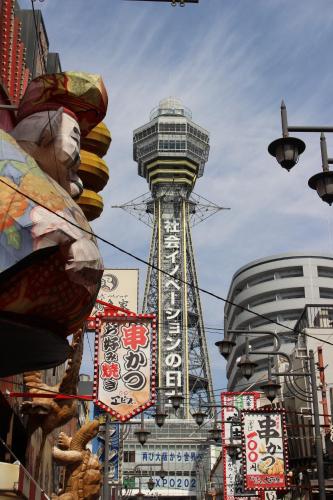 a tall building with a clock tower in a city at Hotel Zipang in Osaka