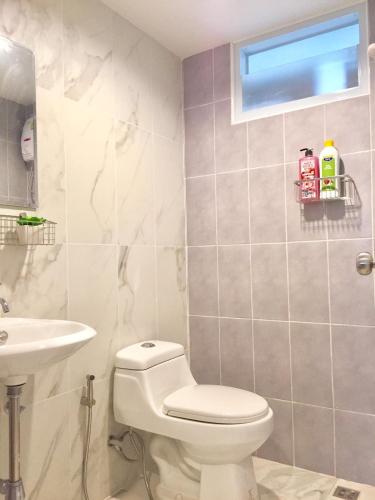 a bathroom with a toilet and a sink at My Home N1 - BTS Ratchathewi in Bangkok