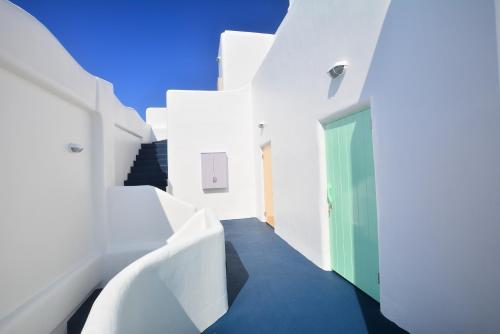 a hallway with white walls and a green door at Mare Cielo in Xiaoliuqiu