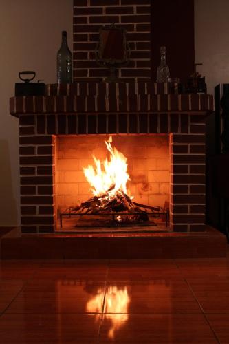 a brick fireplace with a fire in it at Kame House hostel in Huaraz