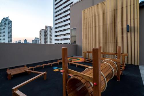 a room with wooden benches on the roof of a building at THEA Private Suites by TH District in Bangkok