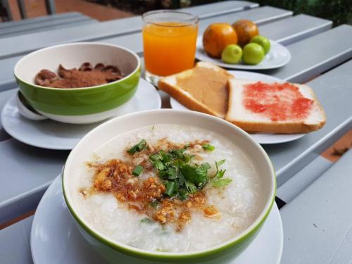 a table with a bowl of soup and a plate of food at Arantarakiri Resort Khao Yai in Mu Si