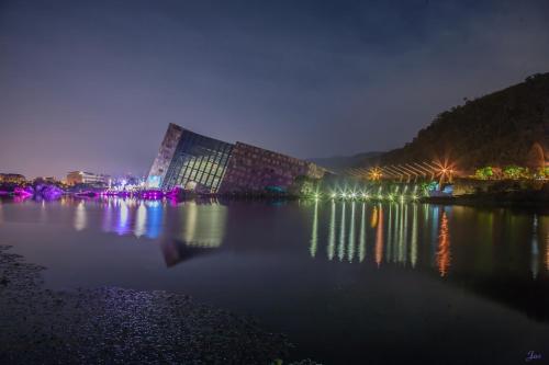 a large building with lights on the water at night at Stay Homestay in Toucheng