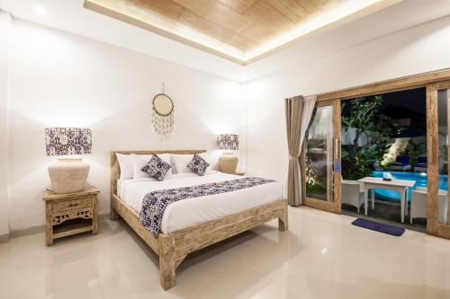 een slaapkamer met een bed en uitzicht op een zwembad bij Ambermoon Villa 2 in Seminyak