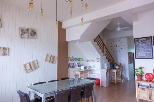 a dining room with a table and a kitchen at Stay Homestay in Toucheng