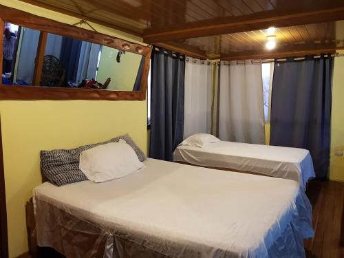 1 dormitorio con 2 camas y ventana en Cabaña Quetzal, en Empalme