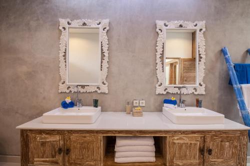 een badkamer met twee wastafels en twee spiegels bij Ambermoon Villa 2 in Seminyak