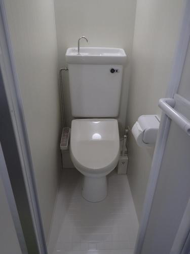 a small white toilet in a small bathroom at Park Avenue Kokubunji in Koganei