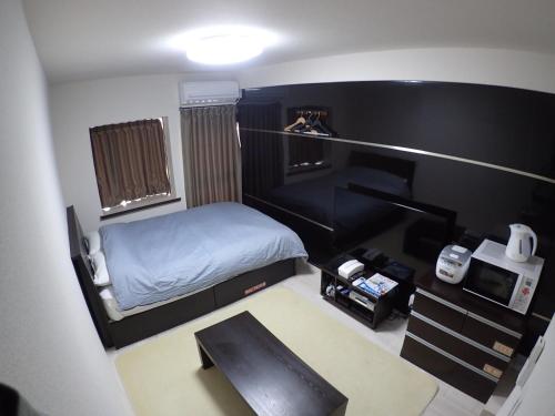 a small room with a bed and a desk at Park Avenue Kokubunji in Koganei