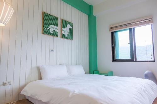 a bedroom with a white bed and a window at Stay Homestay in Toucheng