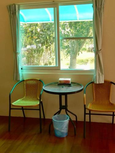 two chairs and a table in front of a window at Chin Shan B&B in Guanshan