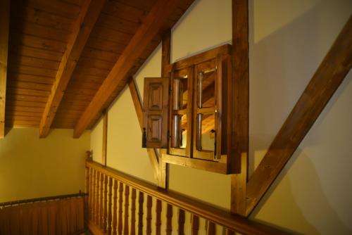 a room with a wooden stair railing and a window at Alojamiento Bernabales in Pámanes