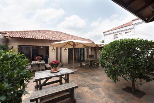 an outdoor patio with benches and an umbrella at Our Heritage Guesthouse in Kempton Park