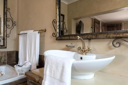 a bathroom with a white sink and a mirror at Our Heritage Guesthouse in Kempton Park
