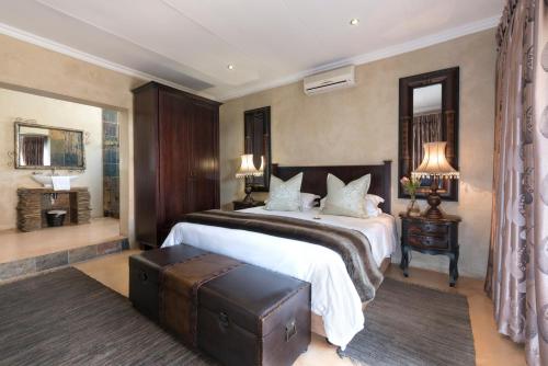 a bedroom with a large bed and a table at Our Heritage Guesthouse in Kempton Park