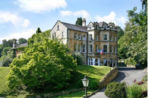 an old house on a hill with a flag on it at Best Western Limpley Stoke Hotel in Bath