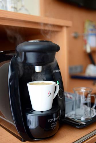a coffee maker with a cup on a counter at Hotel National Düsseldorf (Superior) in Düsseldorf