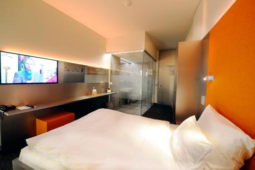 a hotel room with a bed and a tv at Scala Turm Hotel Restaurant in Jena