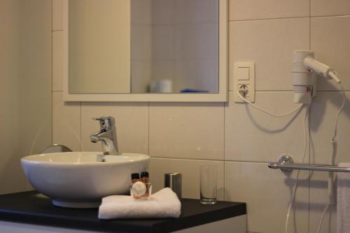 a bathroom with a sink and a mirror at B&B Don Genaro in Dilsen-Stokkem