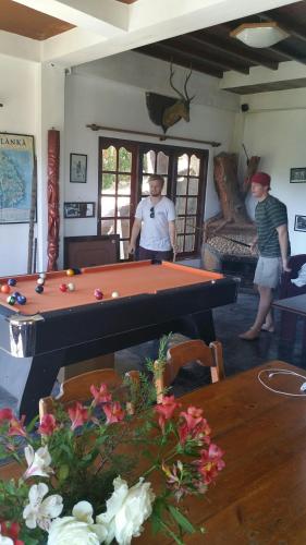 two men standing in a room with a pool table at Misty Mountain Villas in Nuwara Eliya