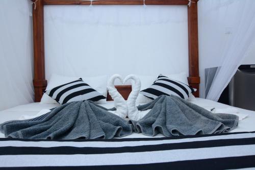 a bed with blue and white blankets and pillows at Hotel City Grand Ella in Ella