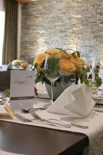 a table with a centerpiece with orange roses on it at Hotel-Gasthaus Engel Luttingen in Laufenburg