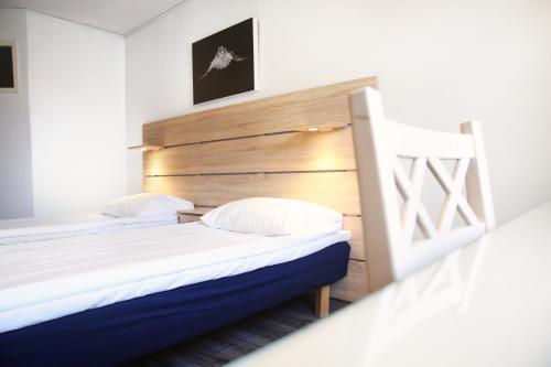 a bedroom with two beds and a wooden headboard at Finlandia Hotel Airport Oulu in Kempele
