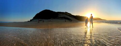 a man and a woman standing on a beach at Machangulo Beach Lodge in Santa Maria