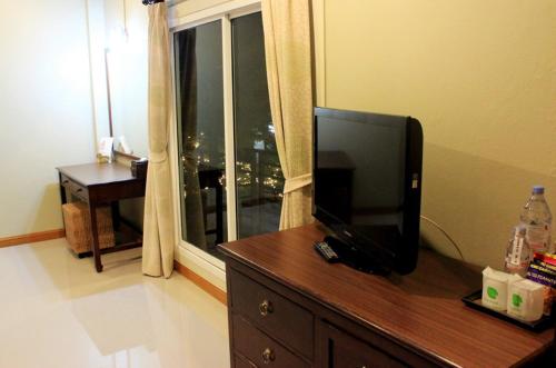 a television on a dresser in a room with a window at Hua Hin White Sand in Hua Hin