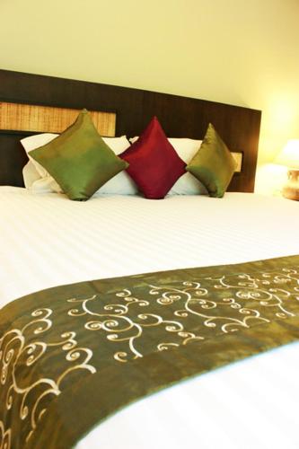 a bedroom with a bed with four pillows at Hua Hin White Sand in Hua Hin