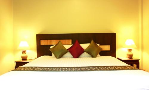 a bedroom with a large bed with four pillows at Hua Hin White Sand in Hua Hin