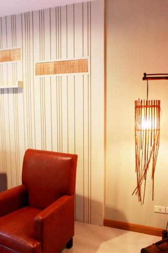 a brown chair sitting in a room next to a wall at Hua Hin White Sand in Hua Hin