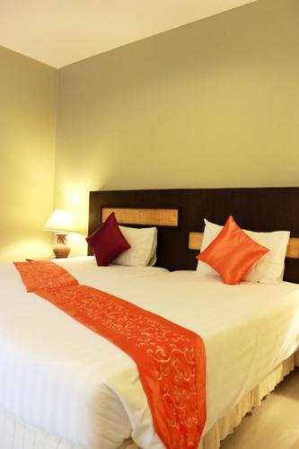 a bedroom with a large bed with orange and white pillows at Hua Hin White Sand in Hua Hin