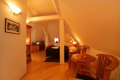 a bedroom with a bed and a table and chairs at Hotel pizzeria Belmonte in Špindlerův Mlýn
