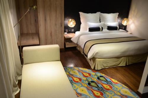 a hotel room with two beds and a chair at HOTEL dGATES in Lahore