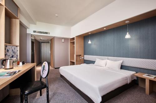 a hotel room with a bed and a desk at Kenting City Gate Hotel in Hengchun