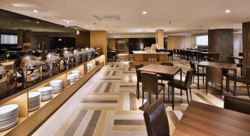 a restaurant with tables and chairs and plates on display at Kenting City Gate Hotel in Hengchun