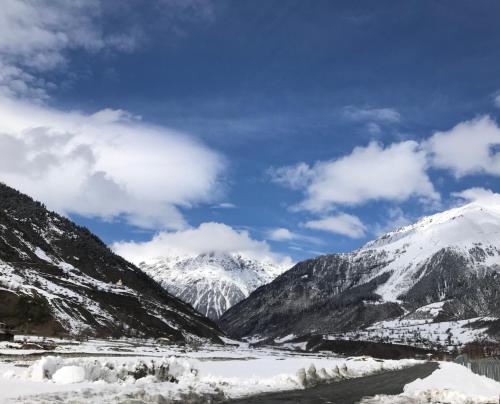 a view of snow covered mountains and a river at Boutique hotel mestia in Mestia