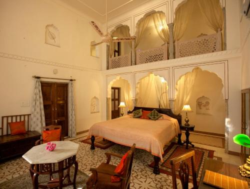 a bedroom with a bed and a table and chairs at Dera Mandawa in Jaipur