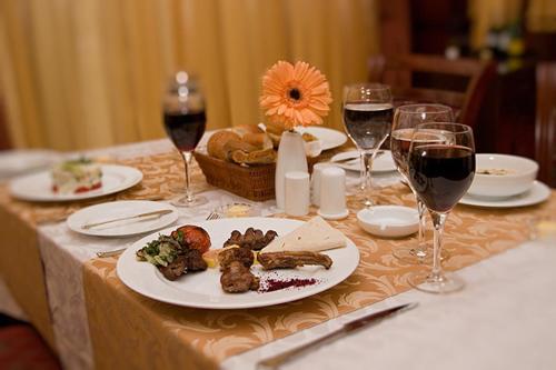 a table with plates of food and glasses of wine at Golden Coast Hotel in Baku