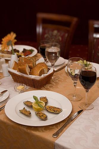 a table with a plate of bread and glasses of wine at Golden Coast Hotel in Baku