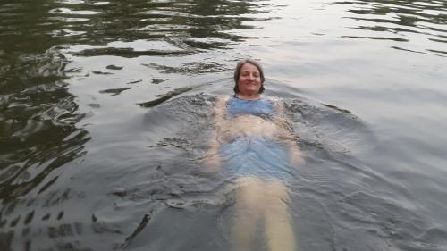 a woman is swimming in the water at Priyanna Guest, Forest view in Polonnaruwa