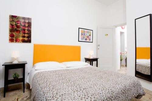 a bedroom with a bed with an orange headboard at Il Vicolo B&B in Milazzo