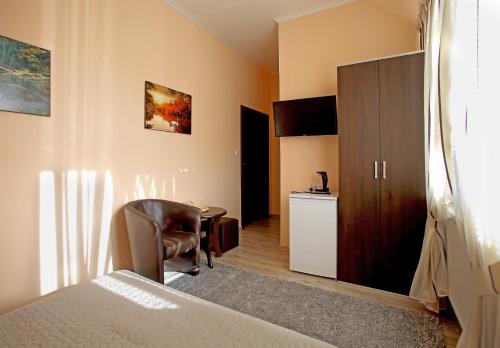a bedroom with a bed and a chair and a cabinet at Kompleks Perła in Łomża